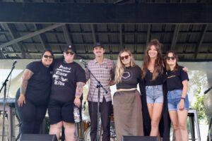 Group of speakers pose for a photo on the Bonnaroo stage