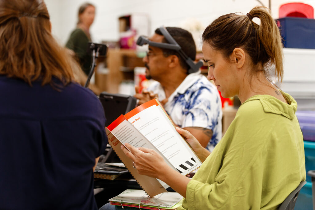 Woman reads the Urban Green Lab Sustainable Classrooms curriculum at a teacher training