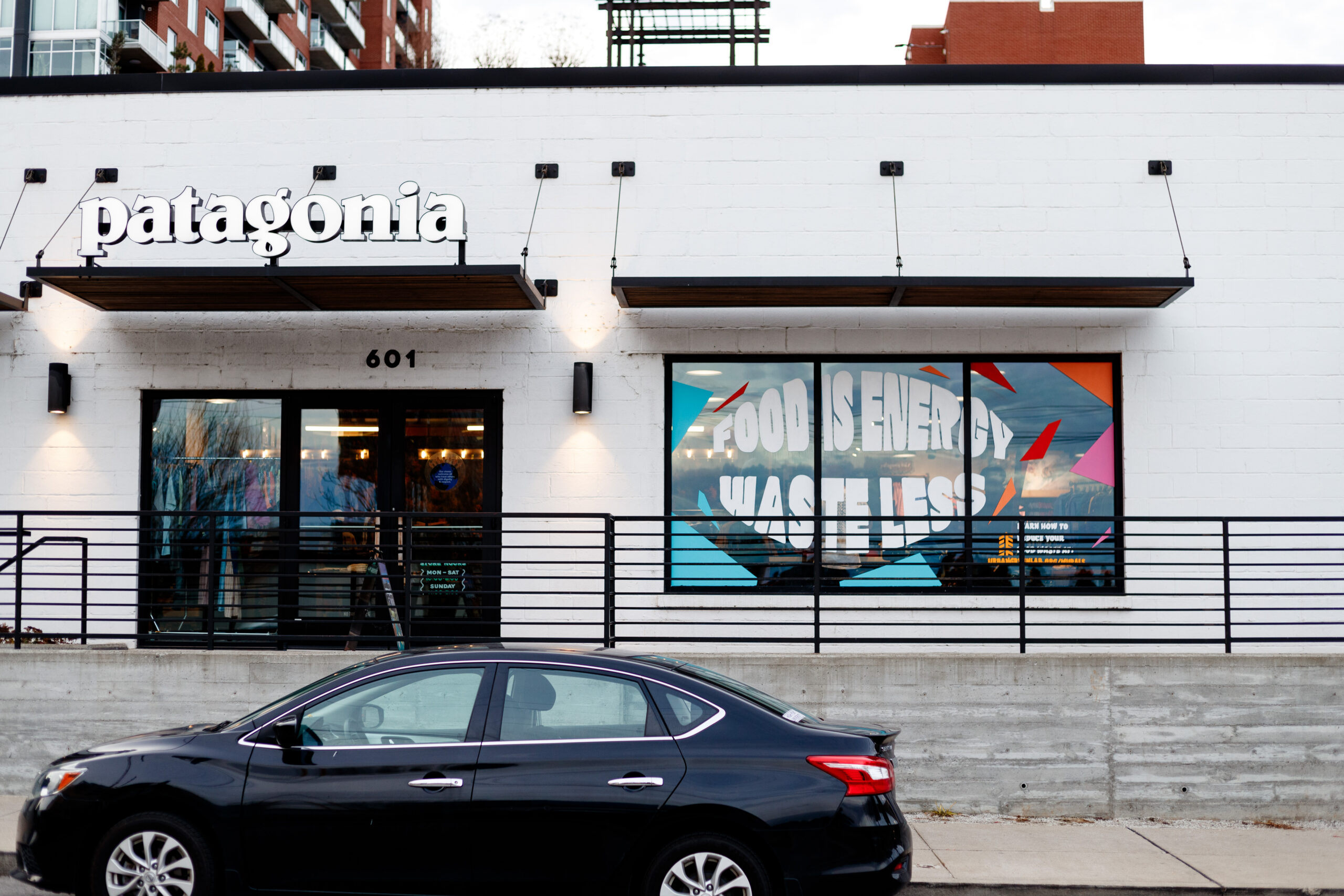 Photo of a white brick building with a Patagonia store sign and a mural painted on the front window