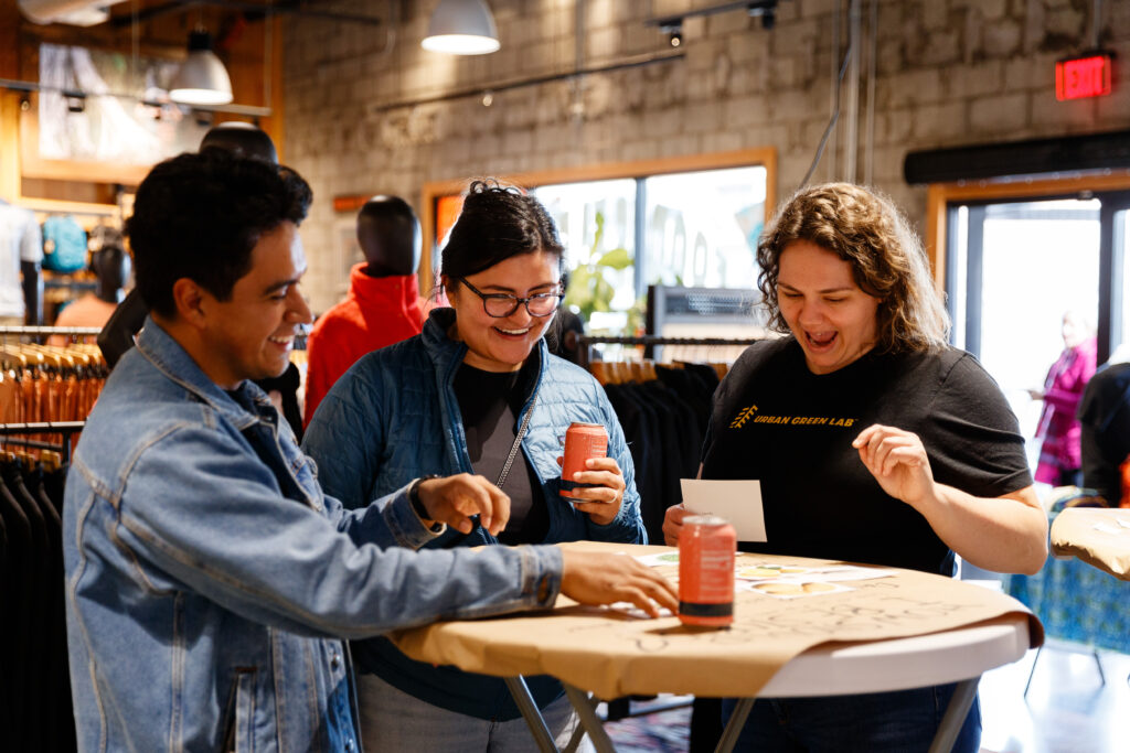 Three people stand at a table and do an educational activity