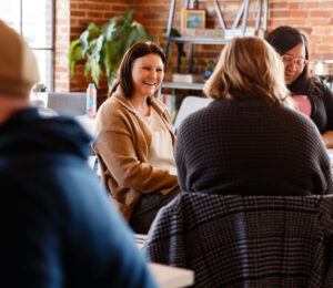 Woman sitting and talking to other people at the table