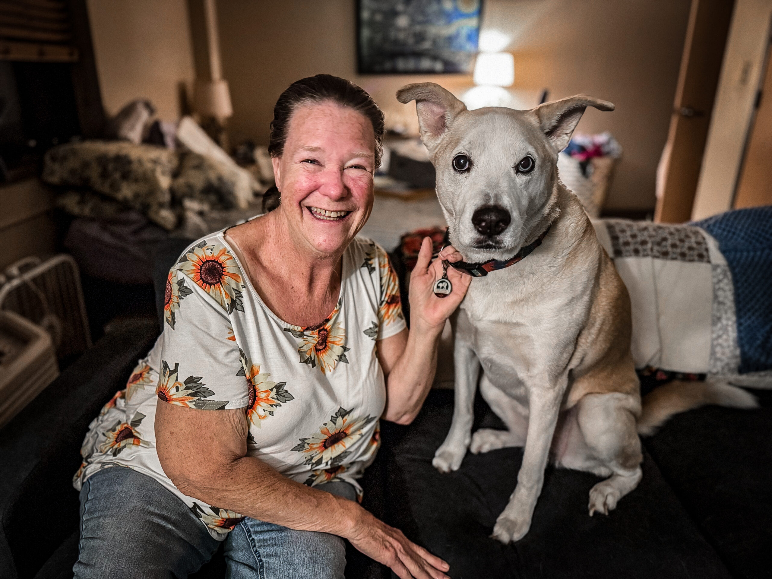 A woman sitting on a couch with her dog