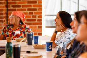 Four women listening to a presentation