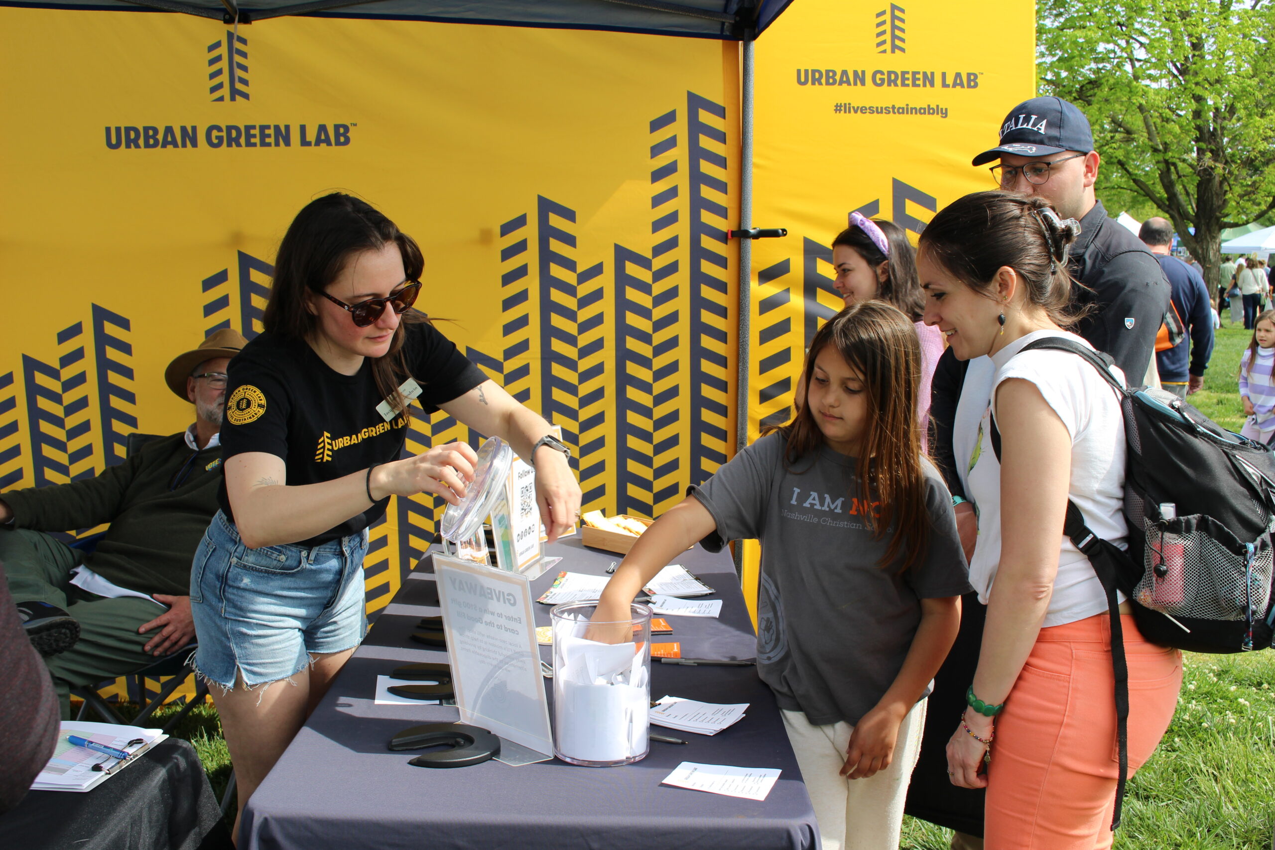 urban green lab staff helping a table visitor find information