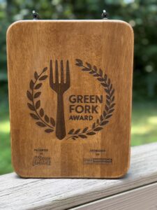 wooden plaque that says "green fork award" with an engraved picture of a fork and wreath