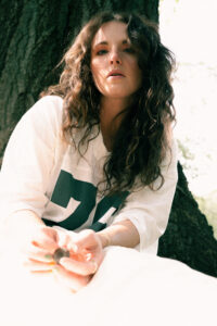 brunette woman in white jersey with green letters