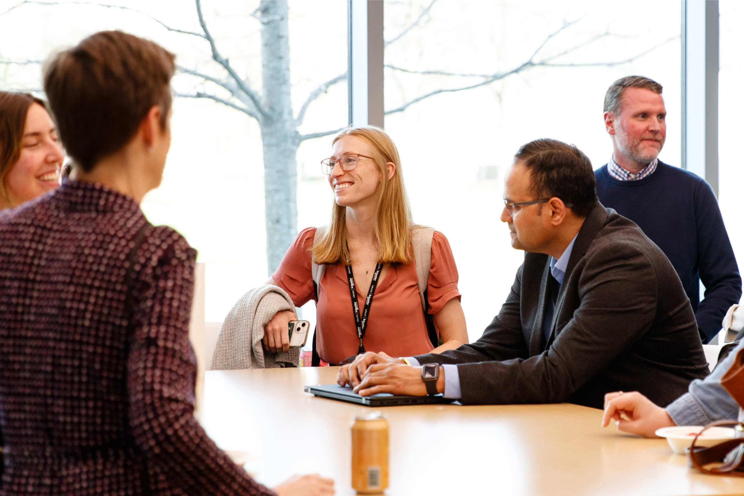 professionals chat around a table during a networking session