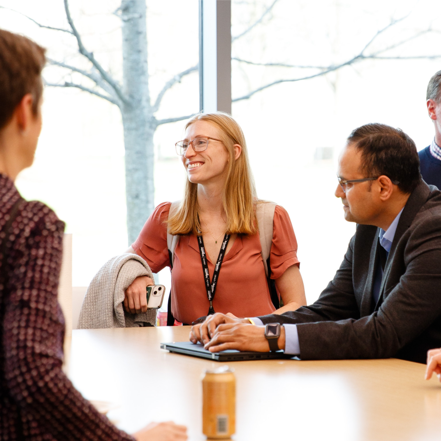 professionals chat around a table during a networking session