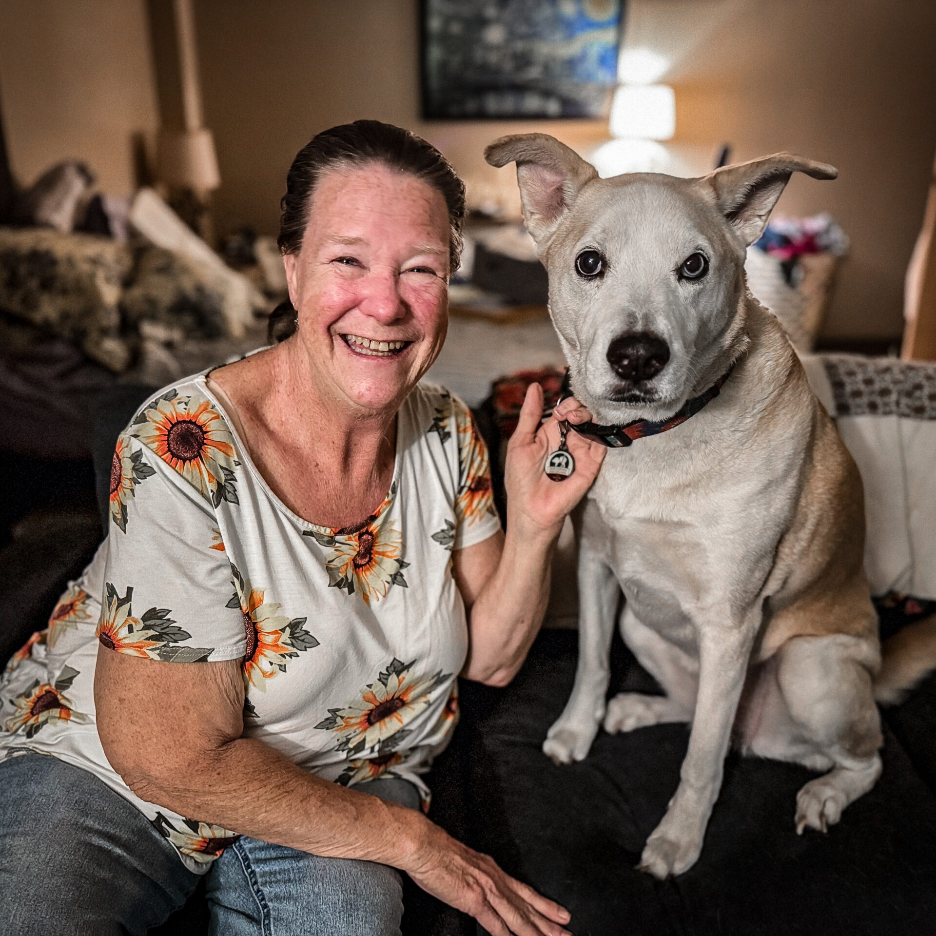 A woman sitting on a couch with her dog