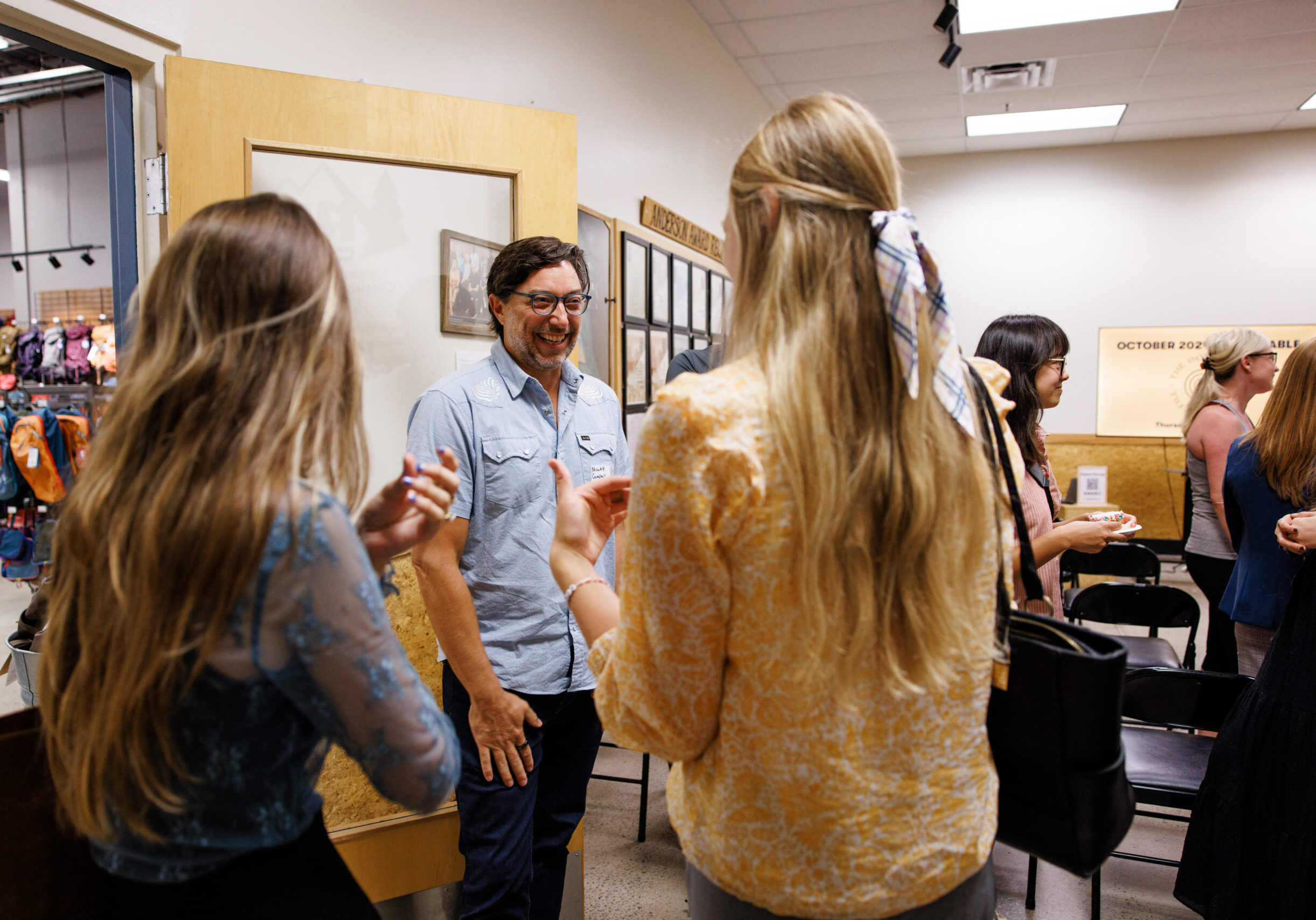 Man laughing and talking to two women