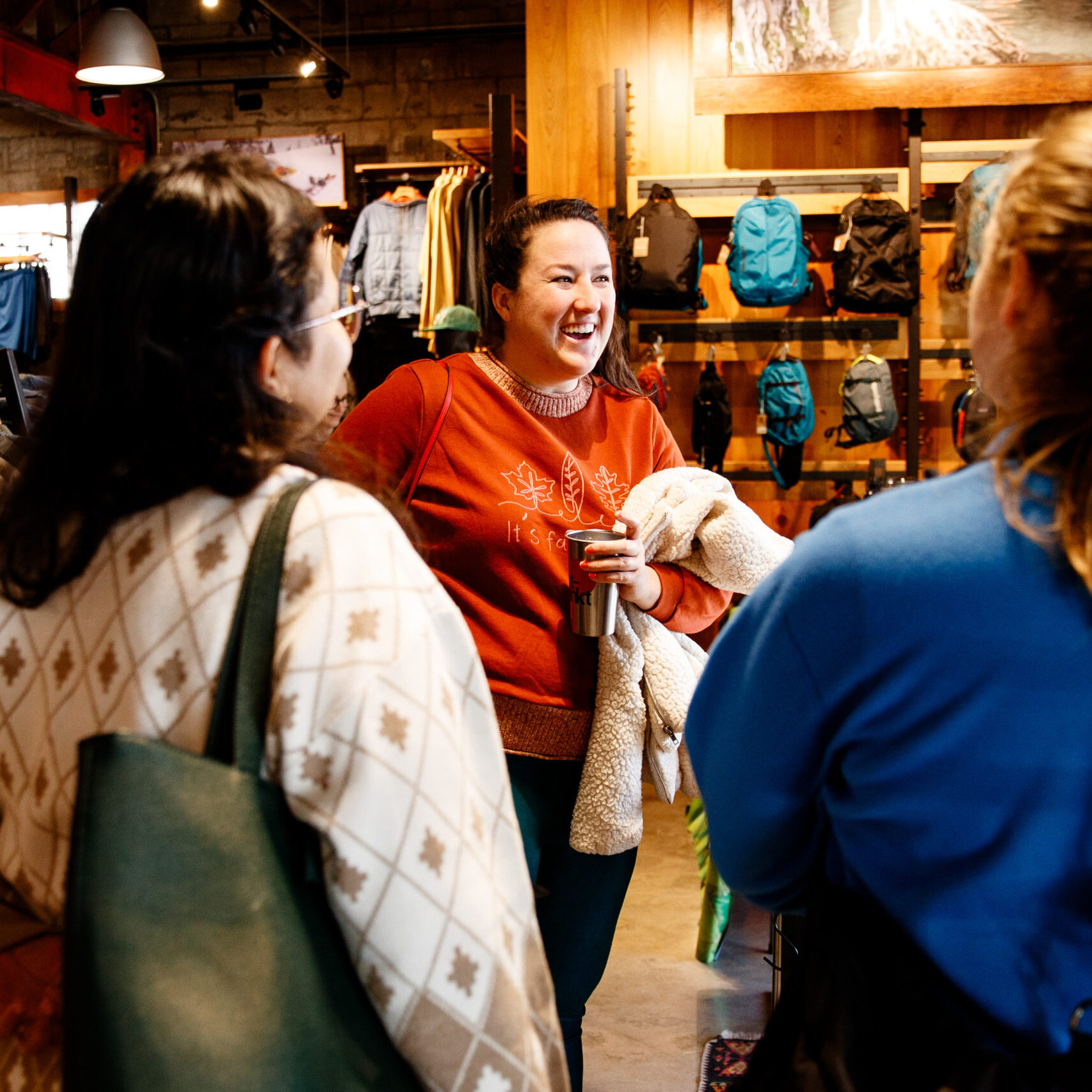 Women in red sweater talking and laughing with two other women