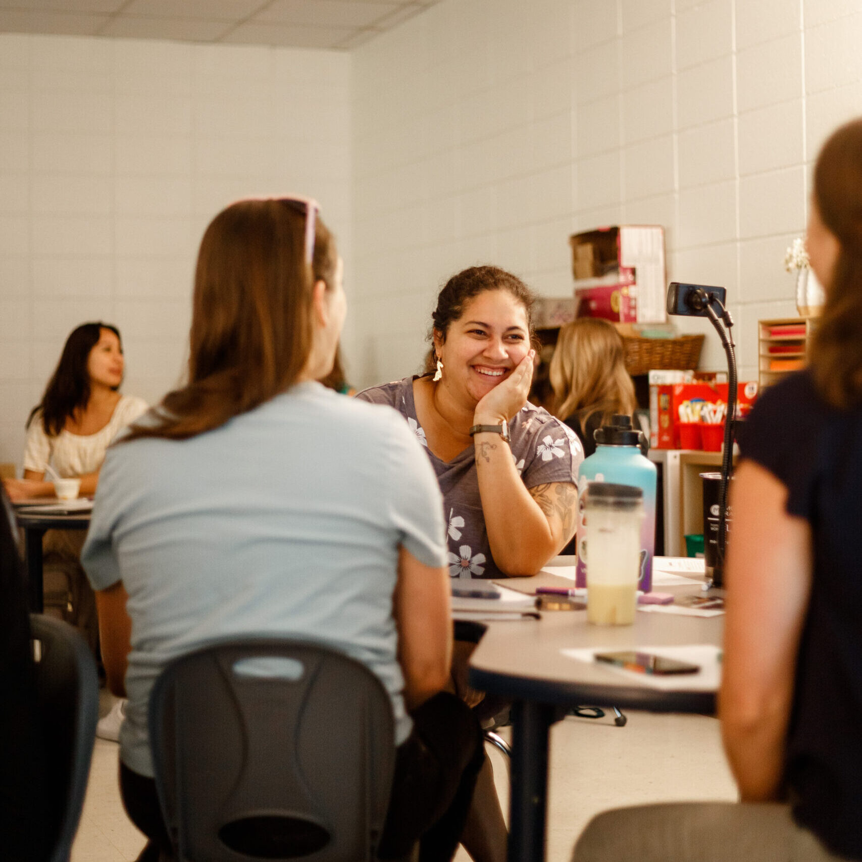 Woman talks to other educators and grins widely