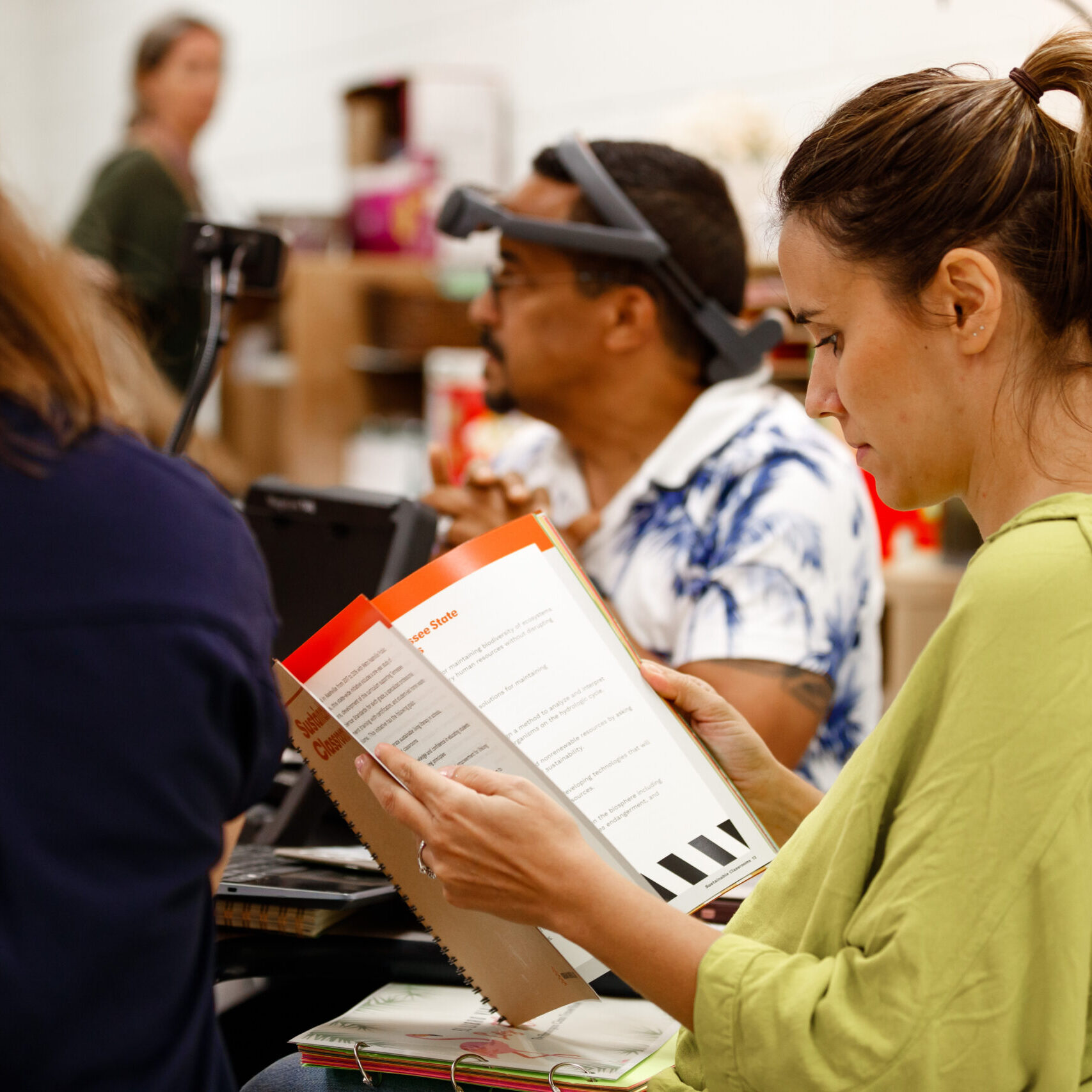 Woman reads the Urban Green Lab Sustainable Classrooms curriculum at a teacher training