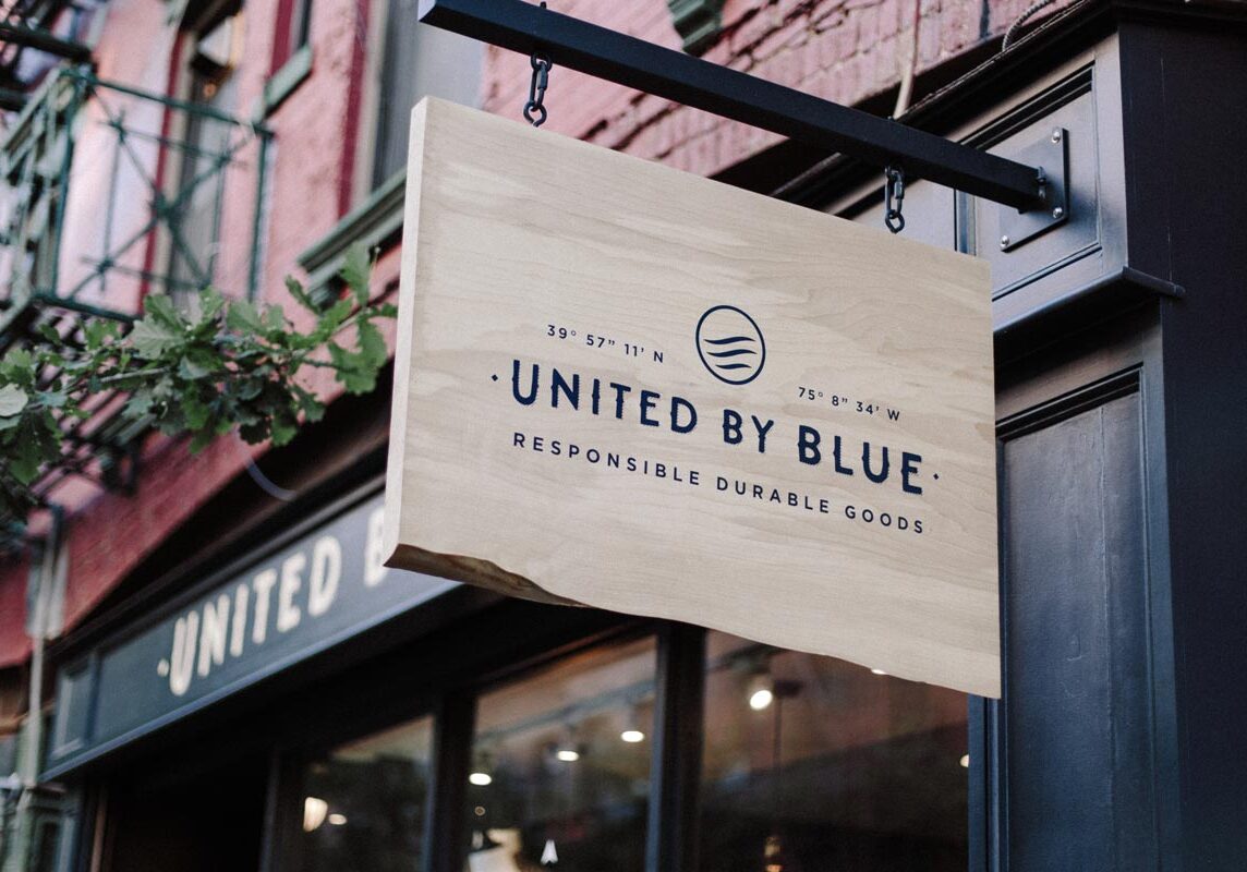 United by Blue wooden sign hanging outside a storefront